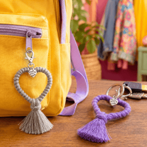 Heart-shaped macrame tassel keychains on backpack and keys